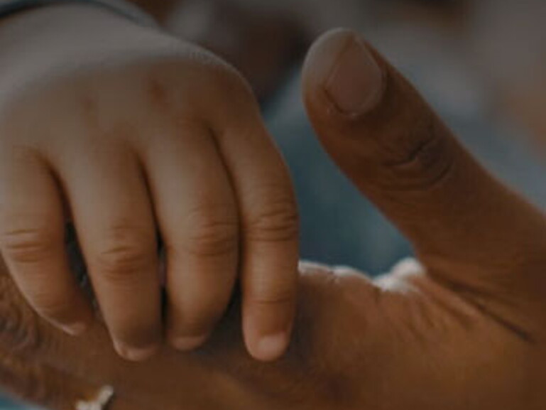 A parent’s hand holding a child’s hand 